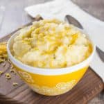 mashed potatoes in a yellow bowl with white flower design