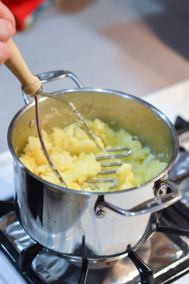 Mashing potatoes with a potato masher