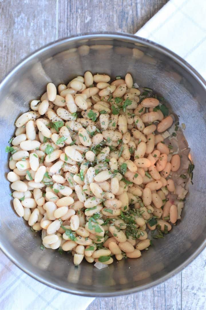 Beans and herbs added to soup pot