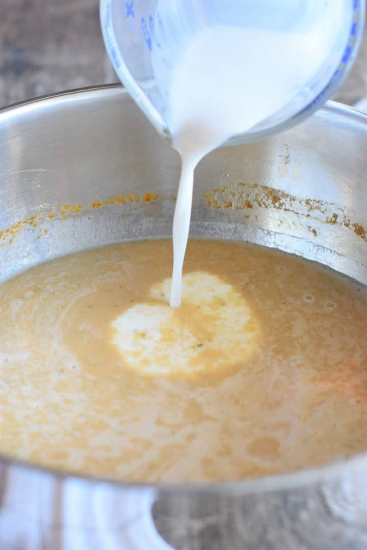 Adding coconut milk to the soup