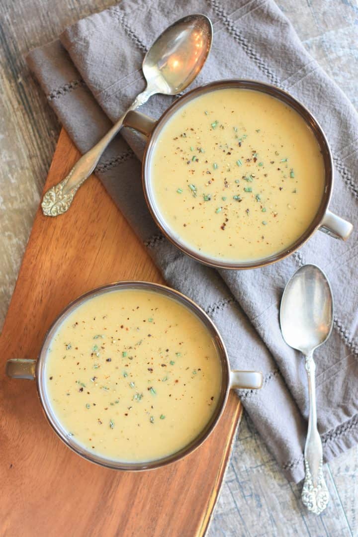 overhead shot of two bowls of soup with spoons next to them