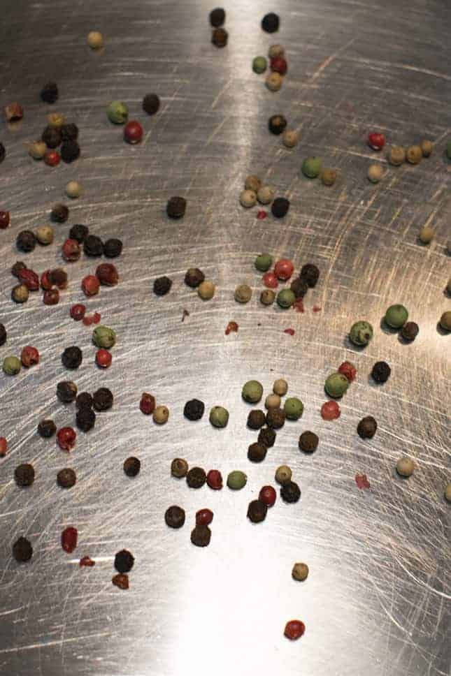 peppercorns toasting in a sauté pan