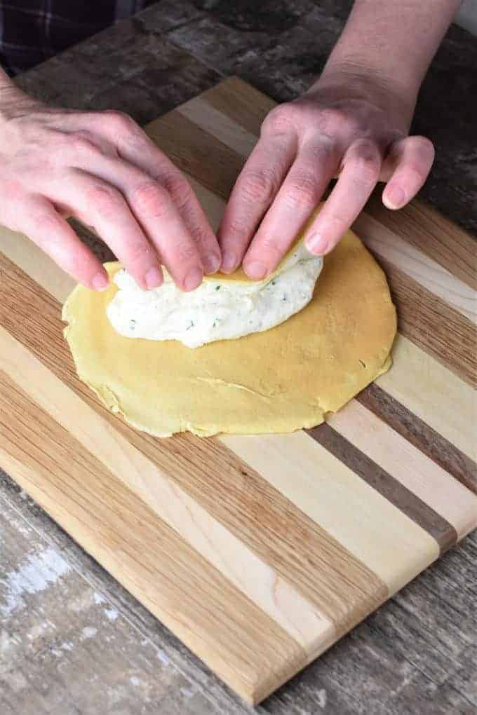 Folding up a manicotti shell (crepe) stuffed with ricotta cheese filling