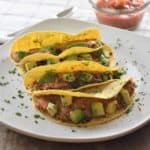 tacos on a white plate garnished with cilantro