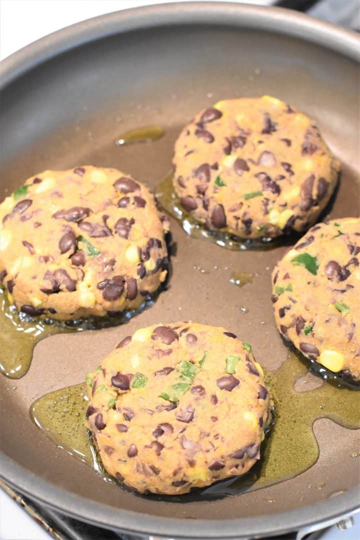 Sweet Potato Black Bean Burgers cooking in a skillet with olive oil