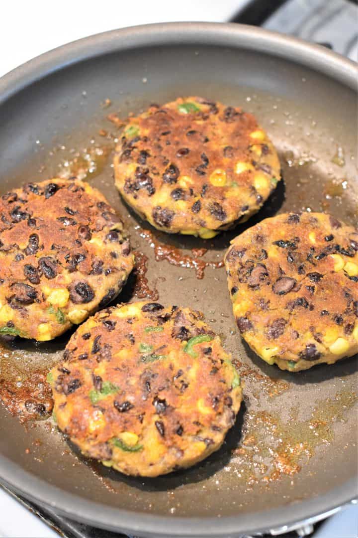 Cooking the sweet potato black bean burgers on the other side after they were flipped