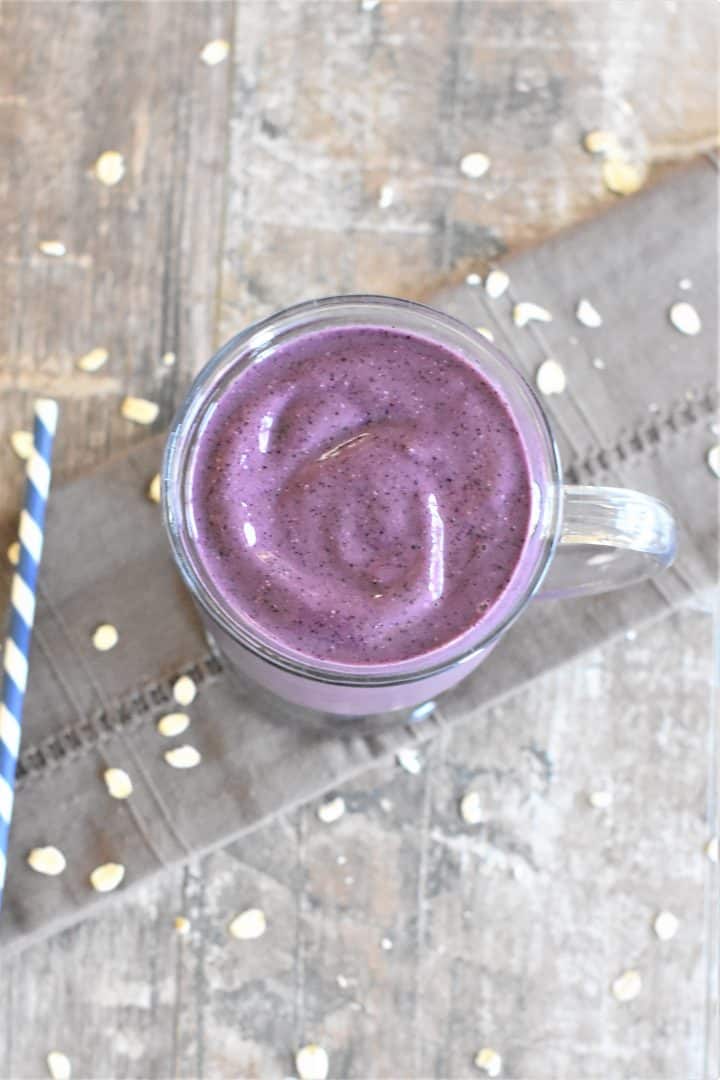 overhead of smoothie in a glass mug with straw on the side