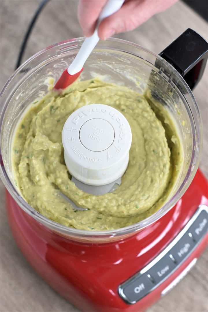 Scraping the sides of a food processor with a spatula