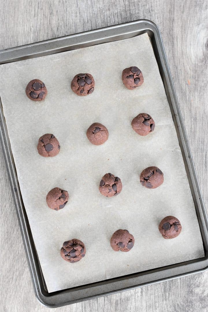 cookie bites on parchment on baking sheet before freezing