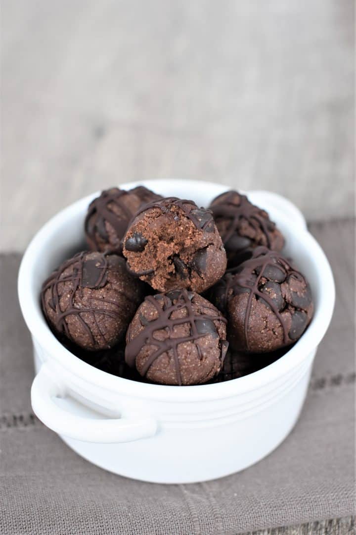 Double Chocolate Chip Cookie Dough Bites in a small white dish with bite taken out of the top one