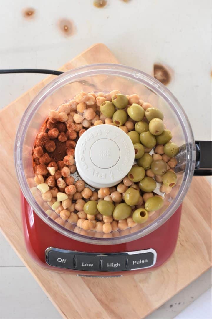 Ingredients for green olive and pimento hummus in a food processor