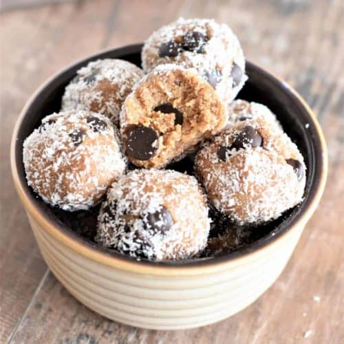 almond butter bites in a small bowl with bite taken out of the top one