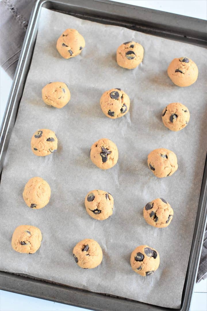 overhead of pumpkin balls after being rolled on the parchment-lined baking sheet