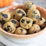 front view of pumpkin bites in a bowl with bite taken out of one of them