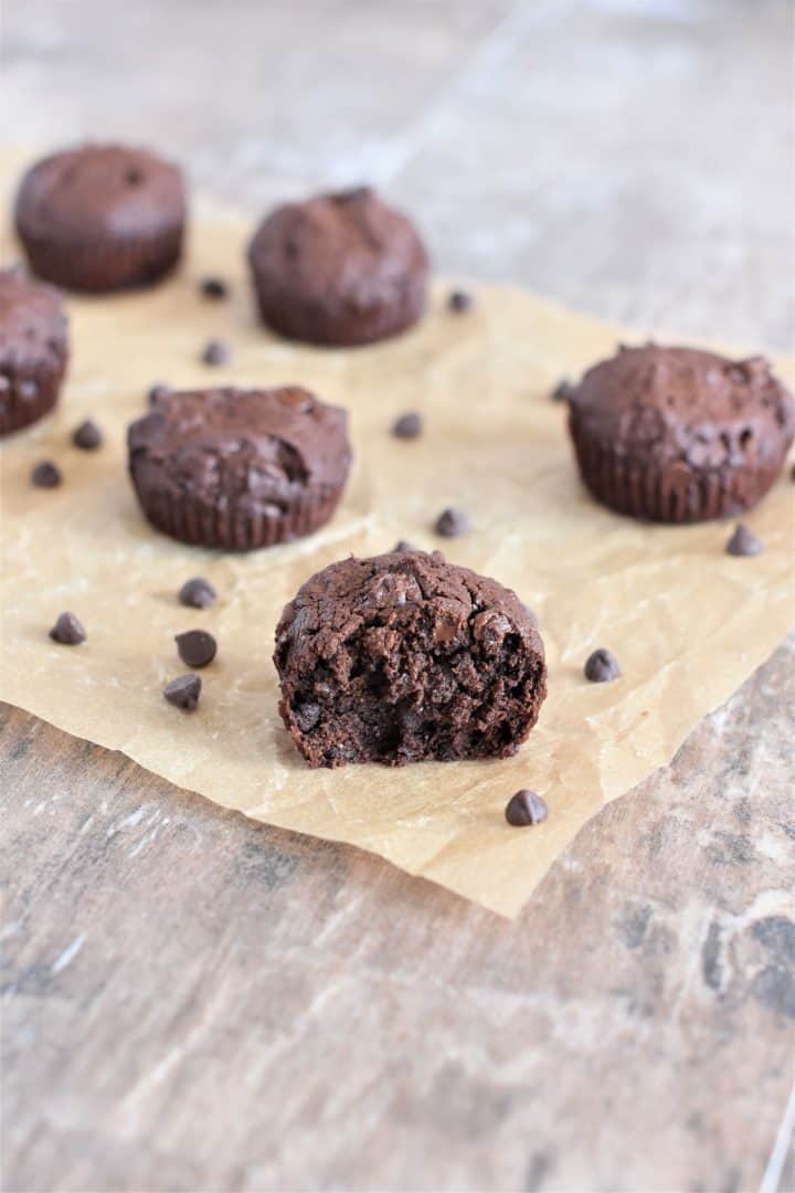 vegan brownie bites on parchment with bite taken out of the one in the front
