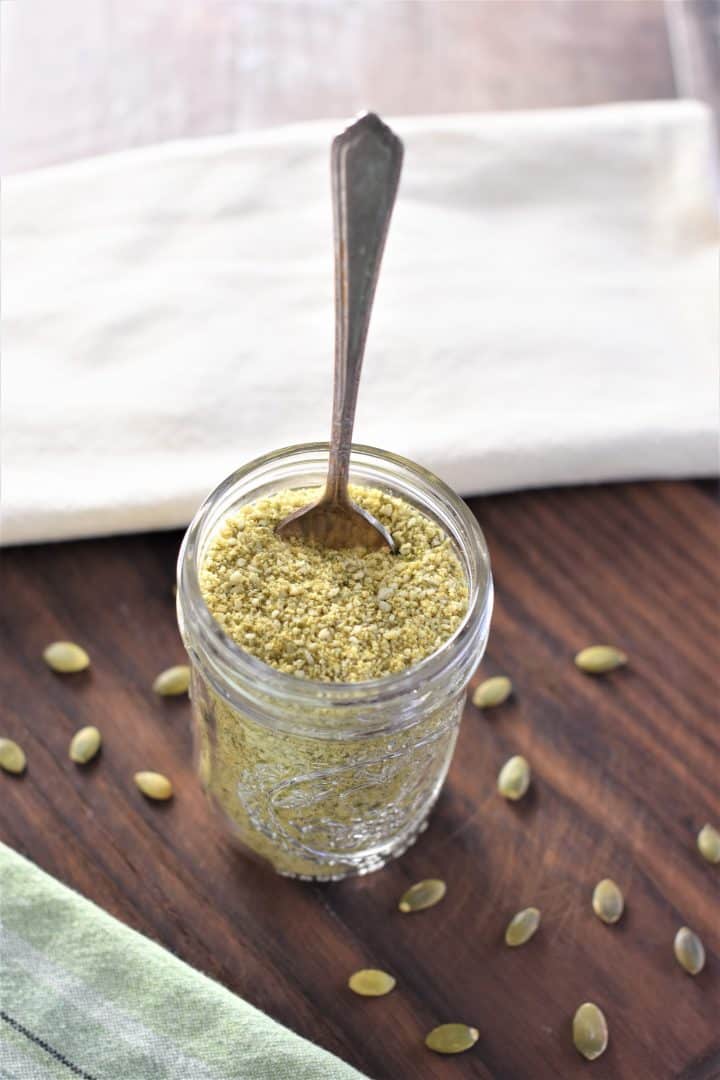 slight overhead of vegan "cheese" in mason jar with spoon in it