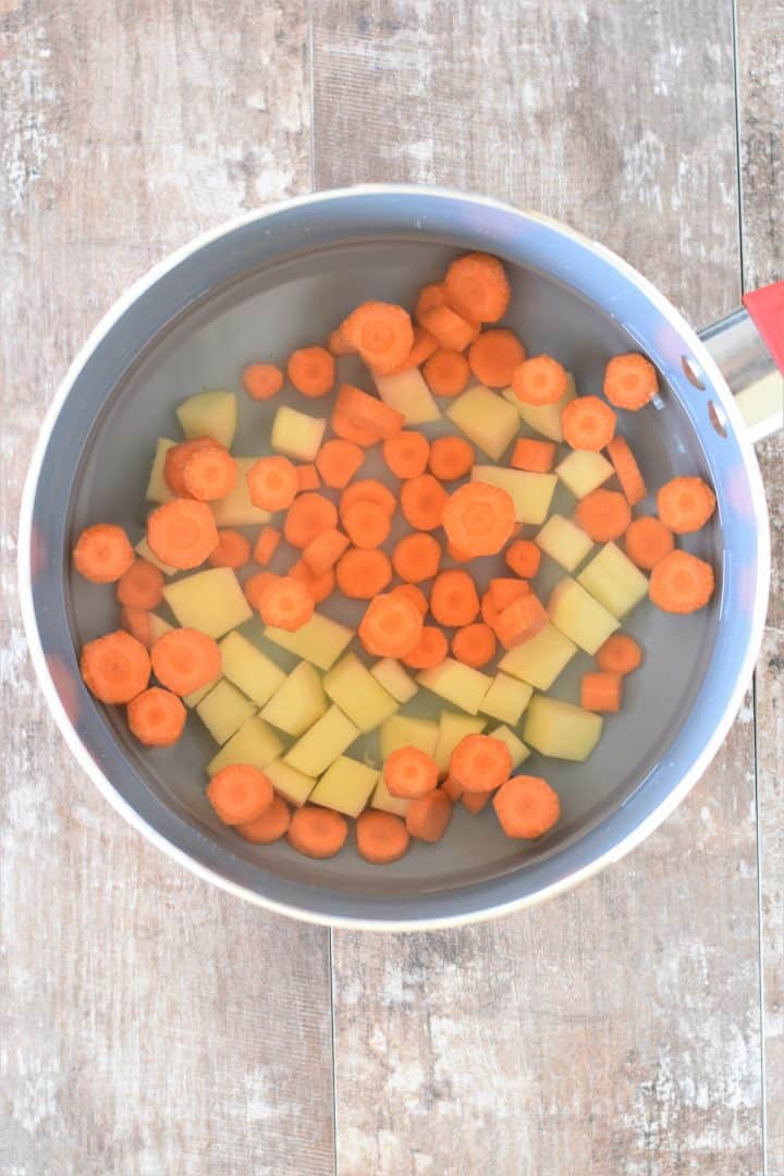 Potatoes and Carrots in water in a saucepan