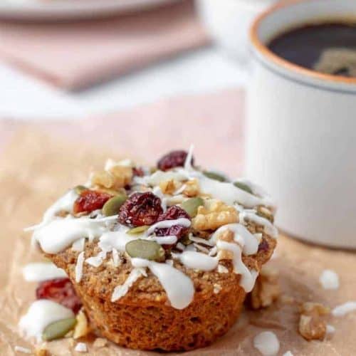 one breakfast muffin on parchment with part of cup of coffee in view next to it