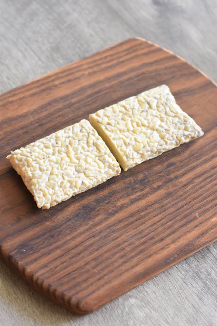 tempeh cut in half on a cutting board