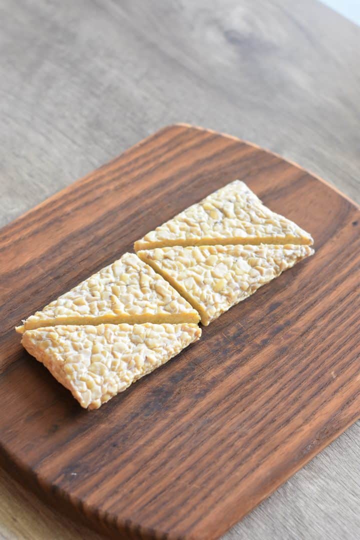 tempeh cut into triangles on a cutting board