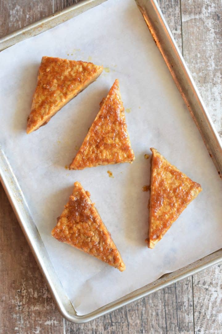 marinated tempeh on a parchment-lined baking sheet