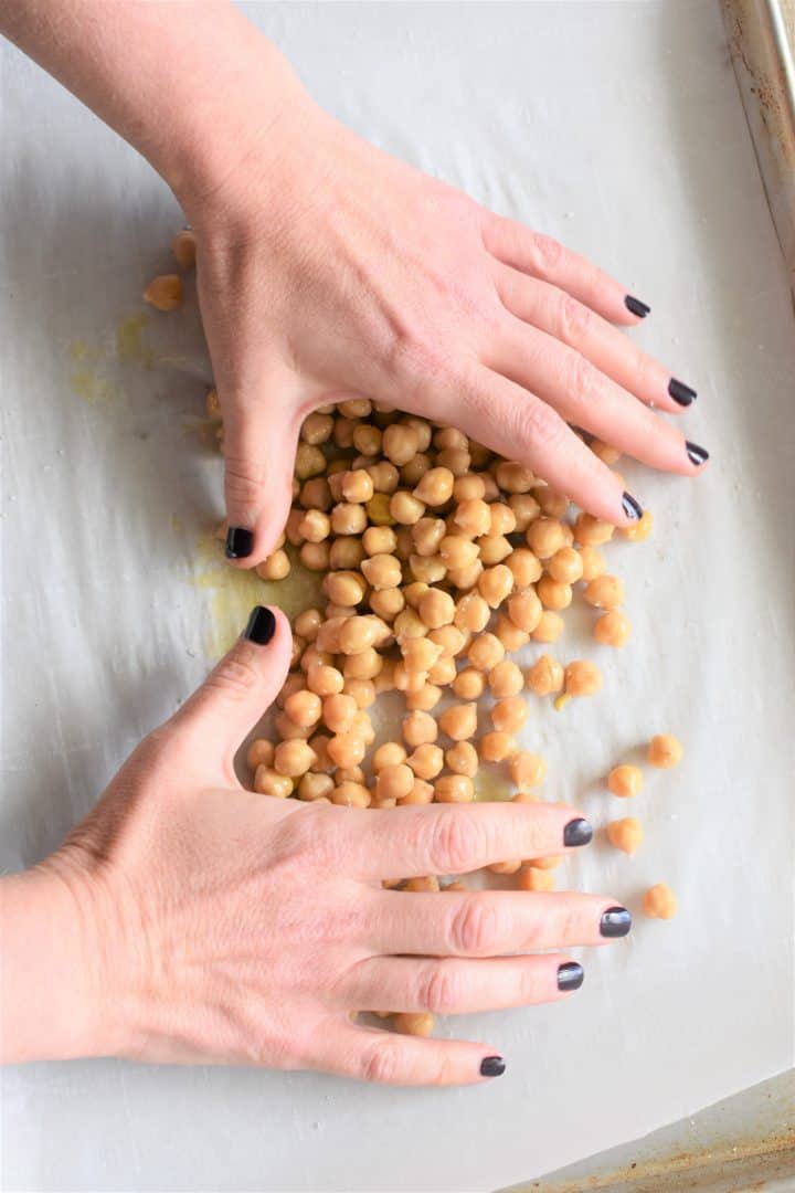 Coating chickpeas with oil and salt using hands