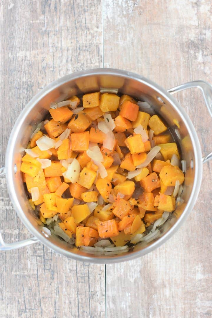 Seasonings and butternut squash added to soup pot