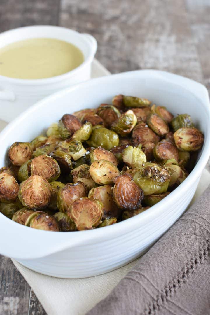 Side view of Brussels sprouts with vegan bechamel sauce in background