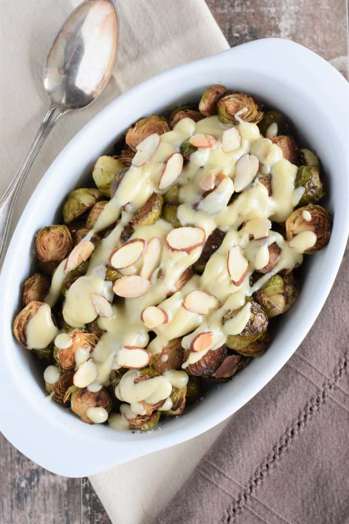 overhead of Brussels sprouts topped with vegan bechamel and toasted almonds