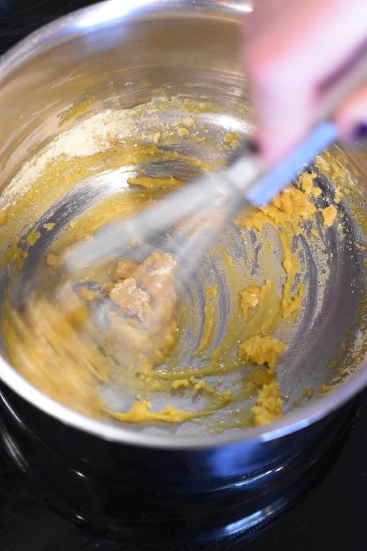 Whisking in chickpea flour to the vegan butter to make a roux