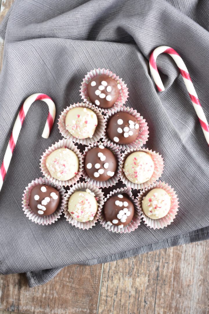 Truffles on a kitchen towel in the shape of a Christmas tree with candy canes around the display