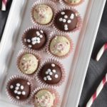 overhead of truffles on a white serving tray with candy canes next to it