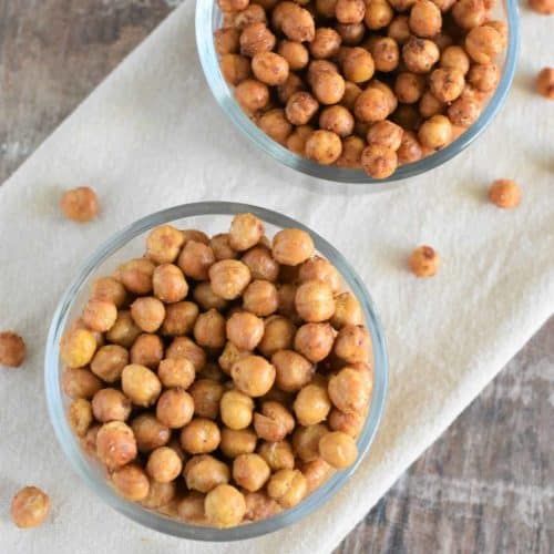 overhead of two flavors of chickpeas in glass bowls on a kitchen towel