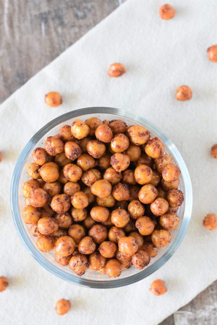 overhead of BBQ chickpeas in bowl on kitchen towel with some on the towel