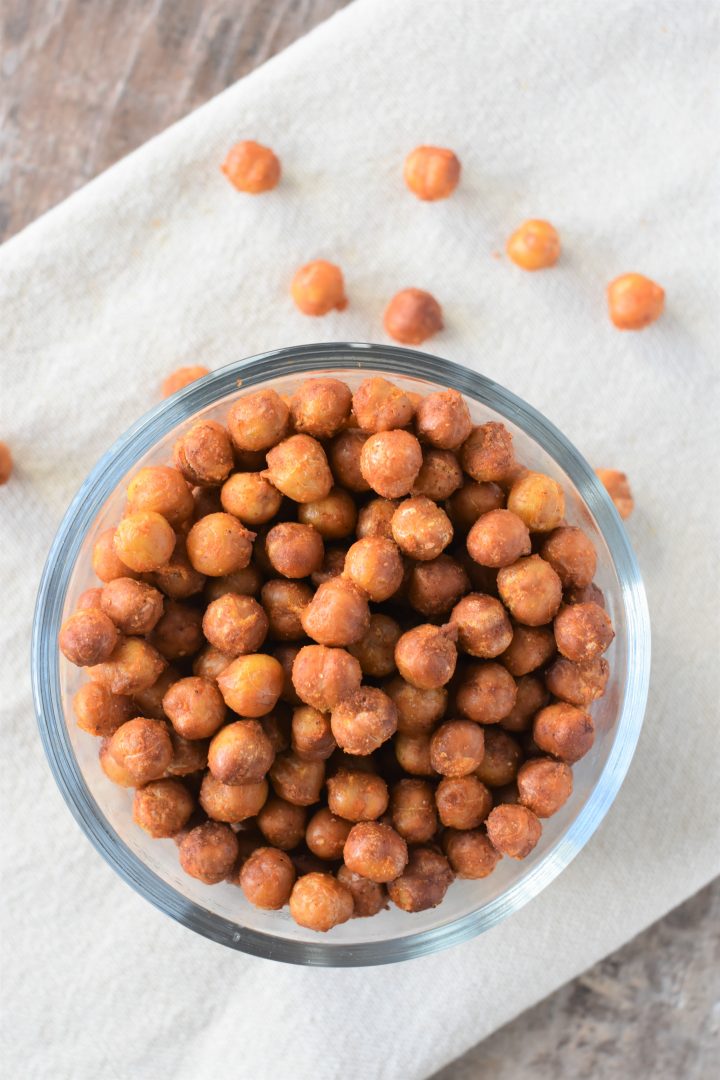 Overhead of Buffalo chickpeas in small bowl on kitchen towel with some on the towel