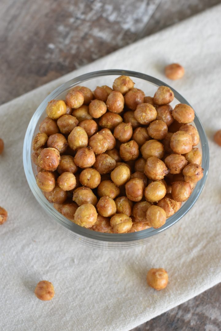 Chickpeas in bowl on kitchen towel with some on the towel