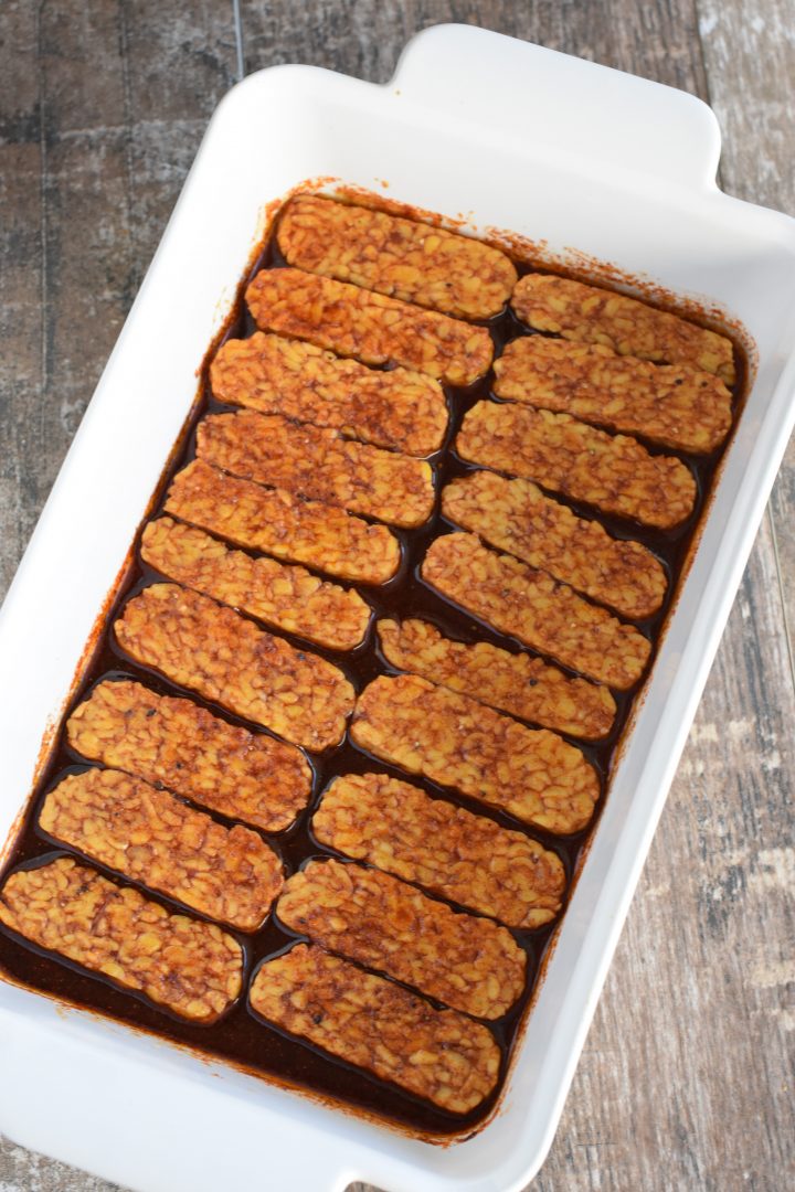 tempeh strips flipped over in the marinade in the baking dish