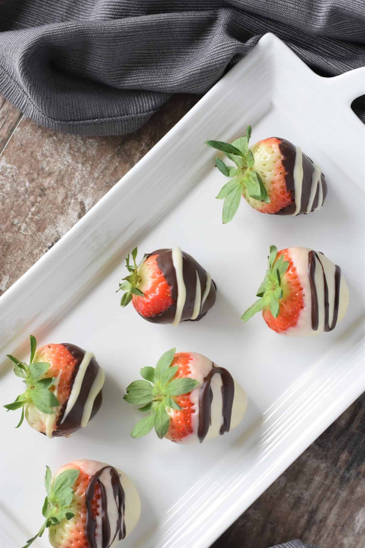 overhead of coated strawberries on white serving platter from the side