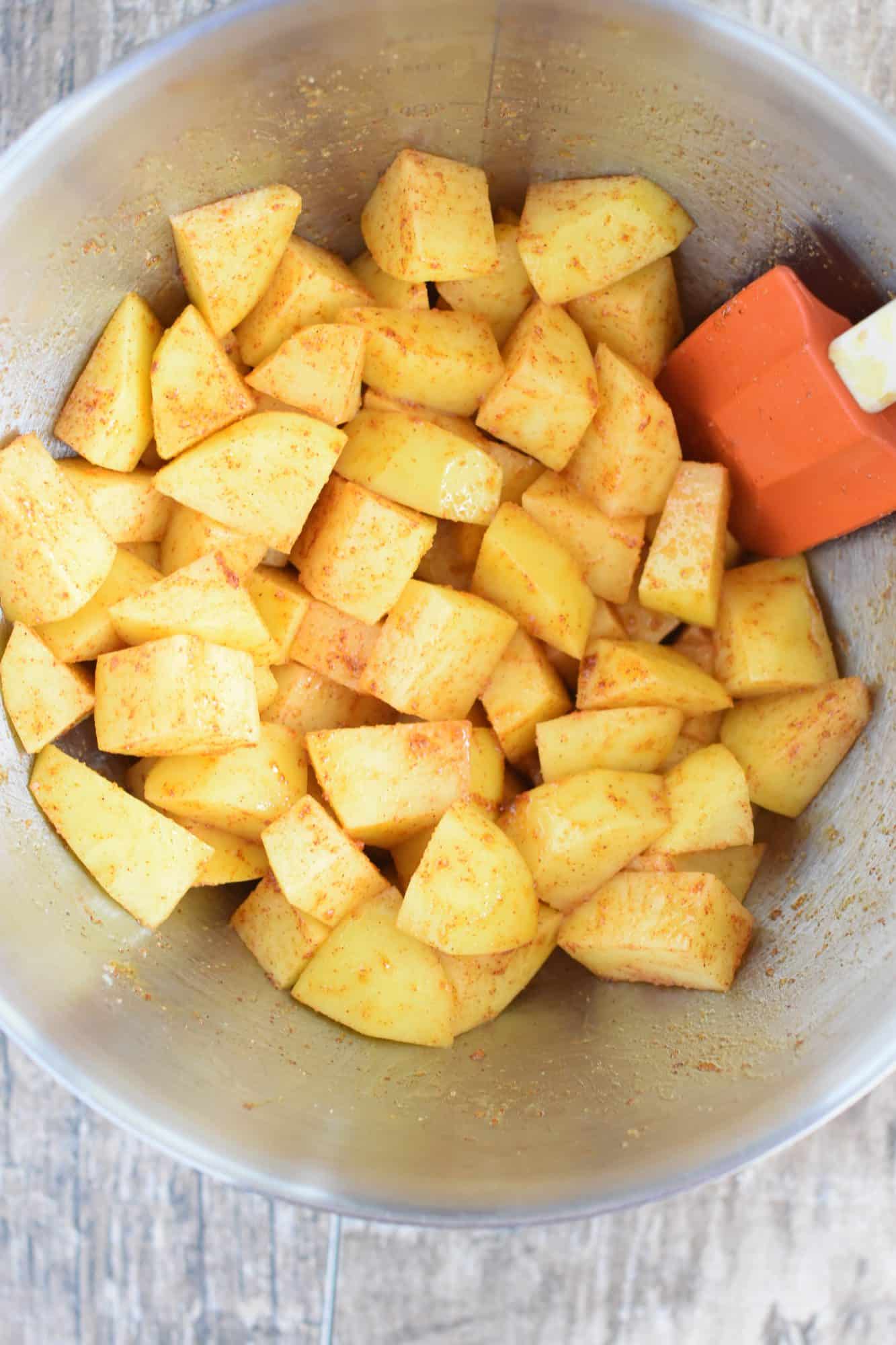 olive oil, paprika, onion powder and salt mixed into the potatoes