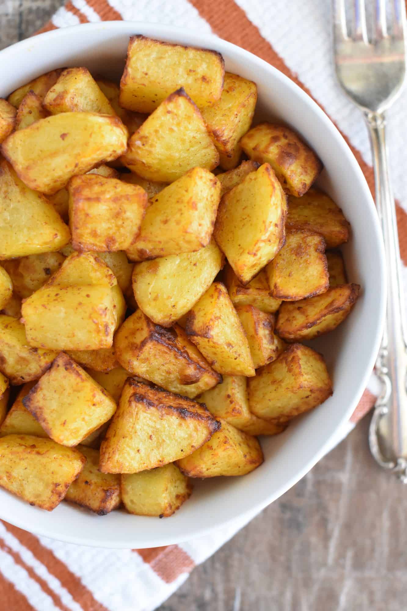 overhead of potatoes in white serving bowl with fork next to it