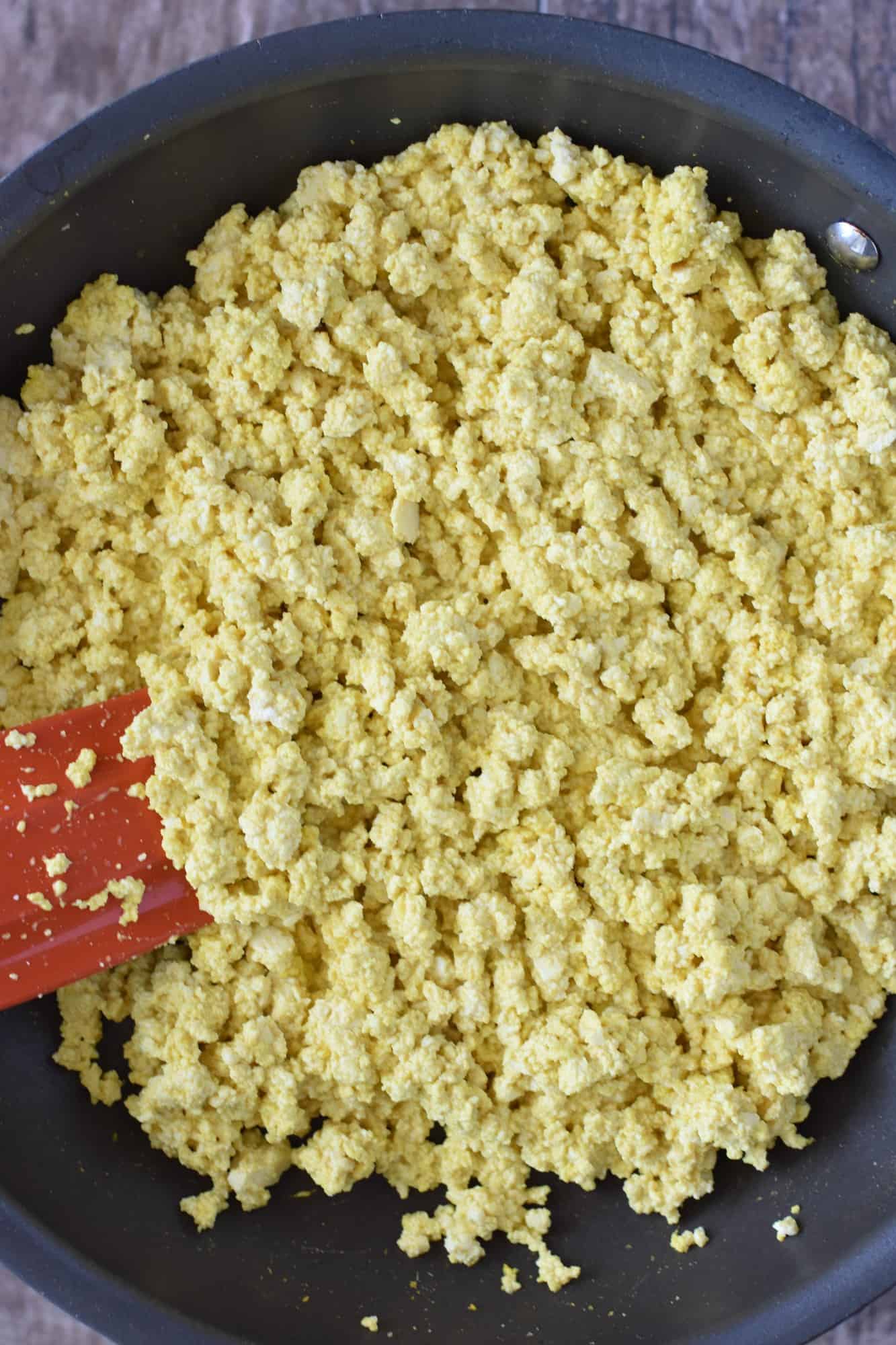 mixing the black salt and turmeric into the tofu