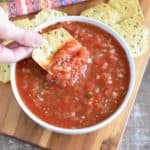 overhead shot of hand holding a chip with some of the salsa on it