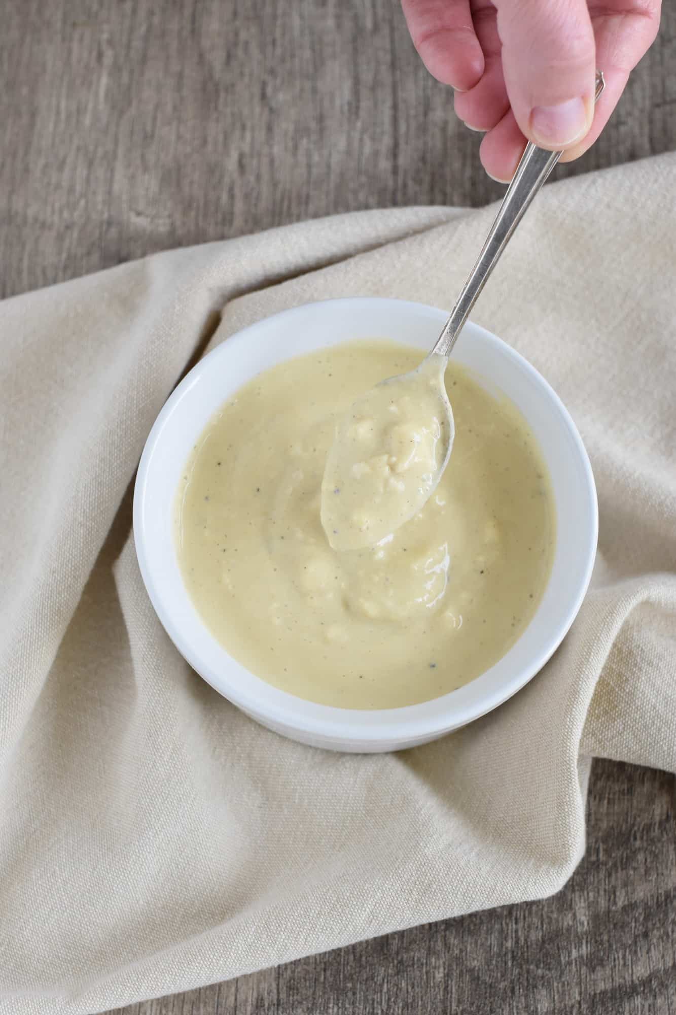 holding up some of the vegan blue cheese dressing with a spoon