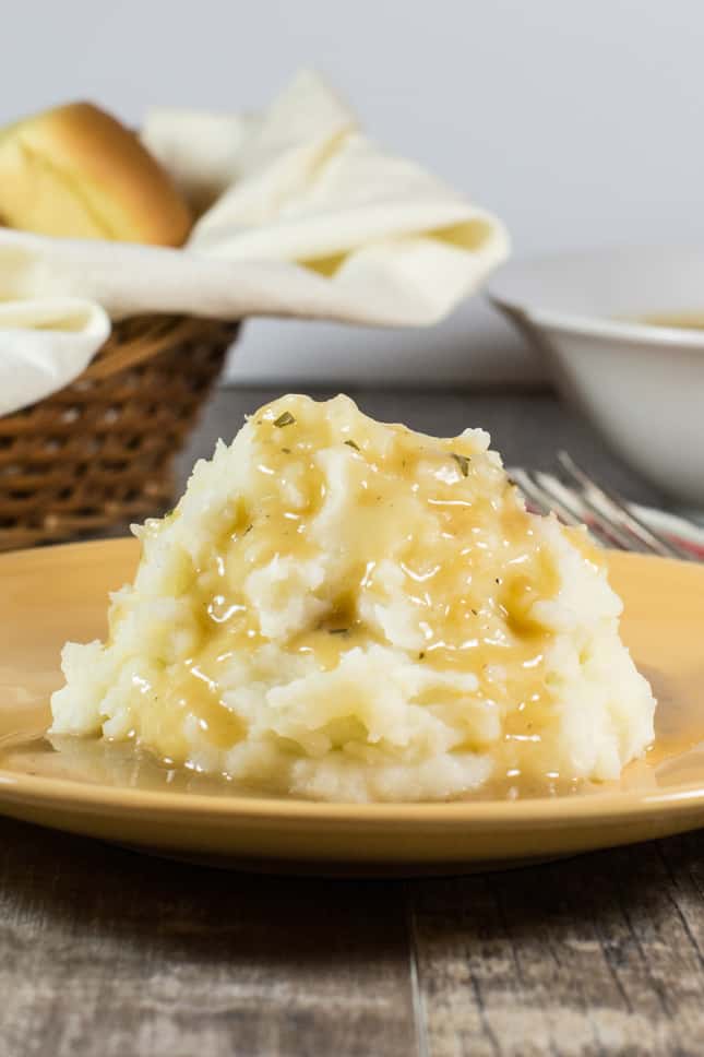 mashed potatoes with gravy on a yellow plate