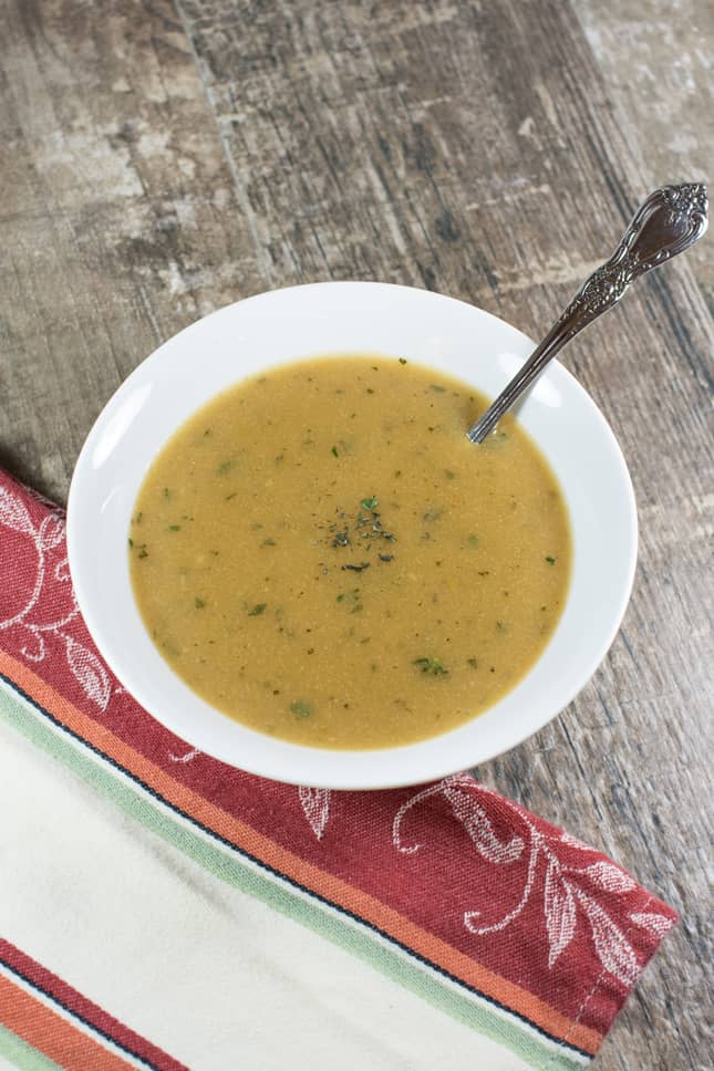 Gluten Free Vegetarian Savory Herb Gravy in a white bowl with a spoon