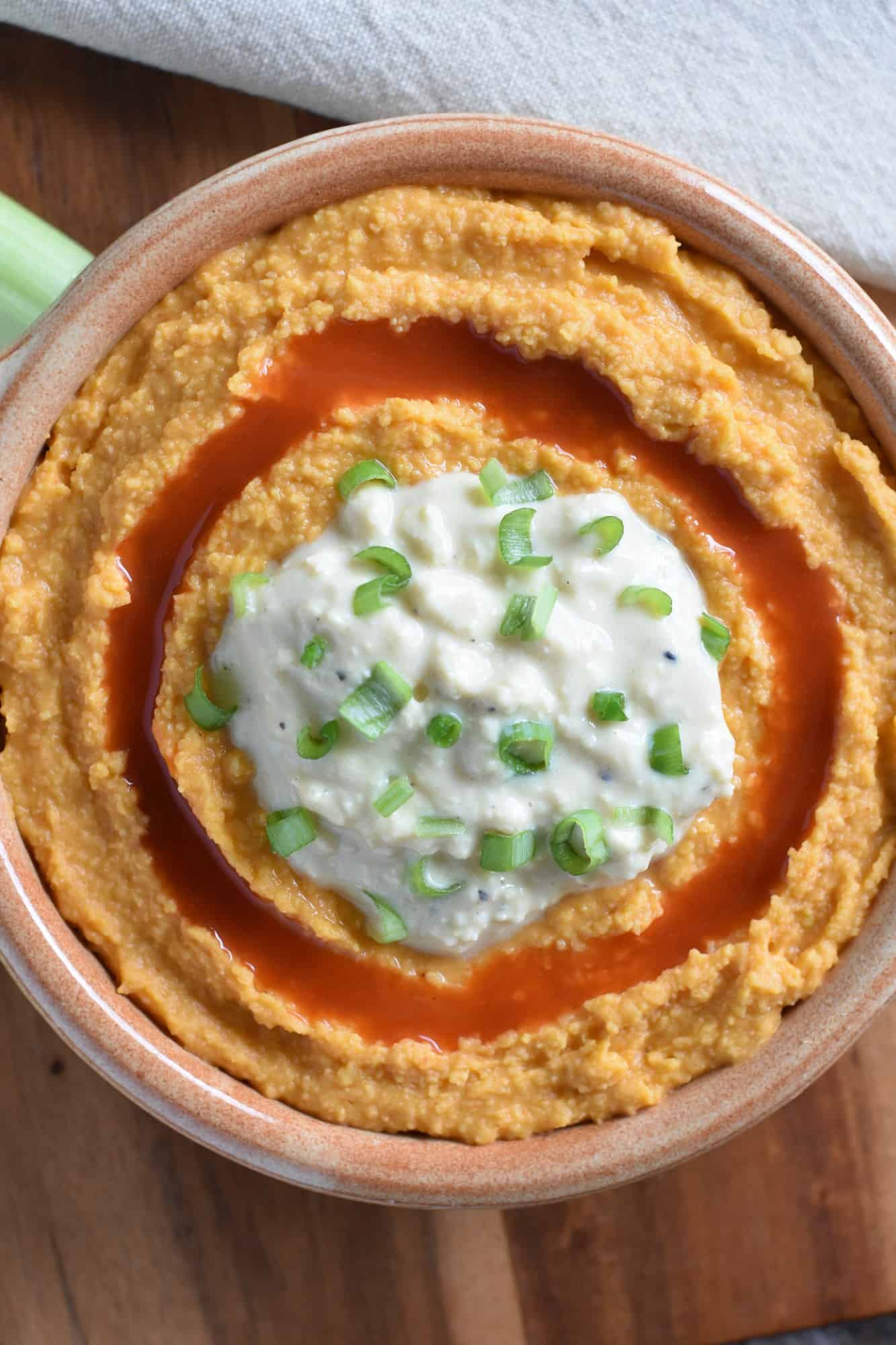 hummus in serving bowl on wooden board