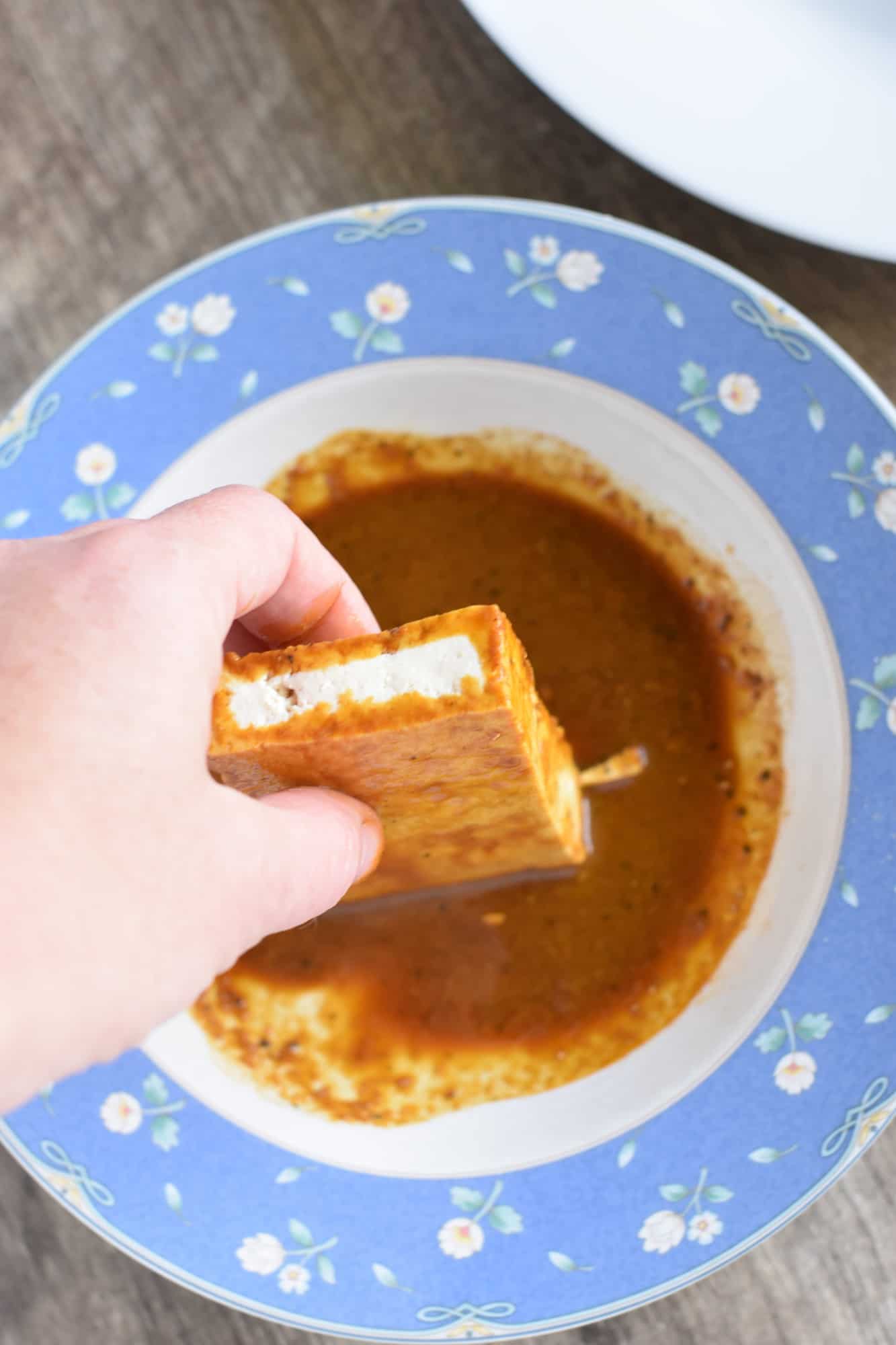 dredging a piece of tofu in the coating