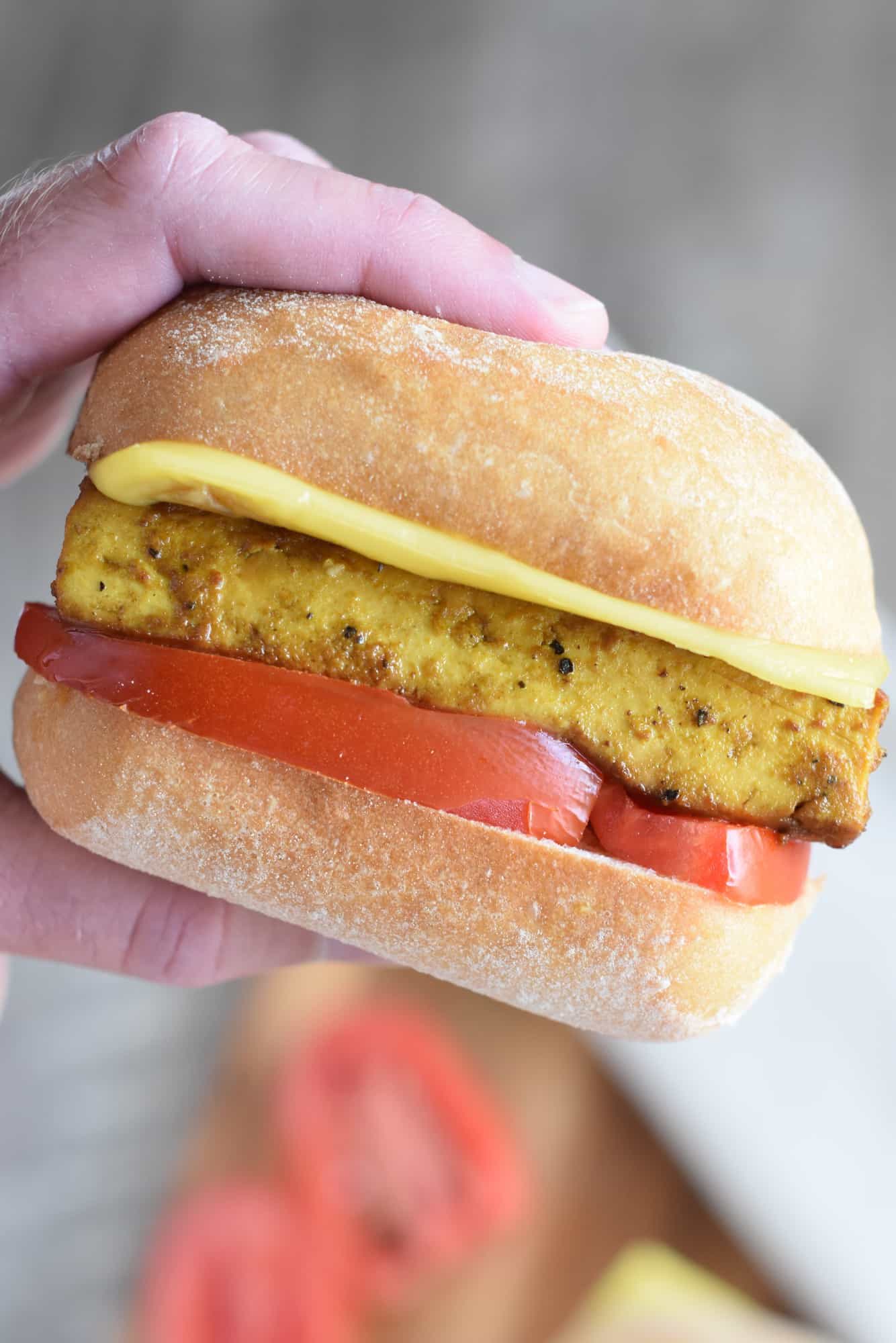 hand holding up one of the breakfast sandwiches