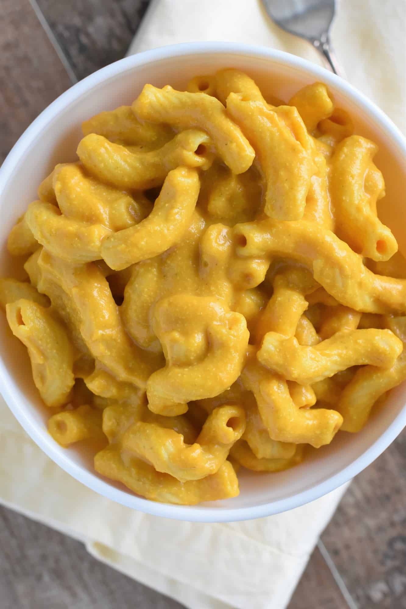 overhead of a serving of mac and cheese in a bowl with a fork next to it