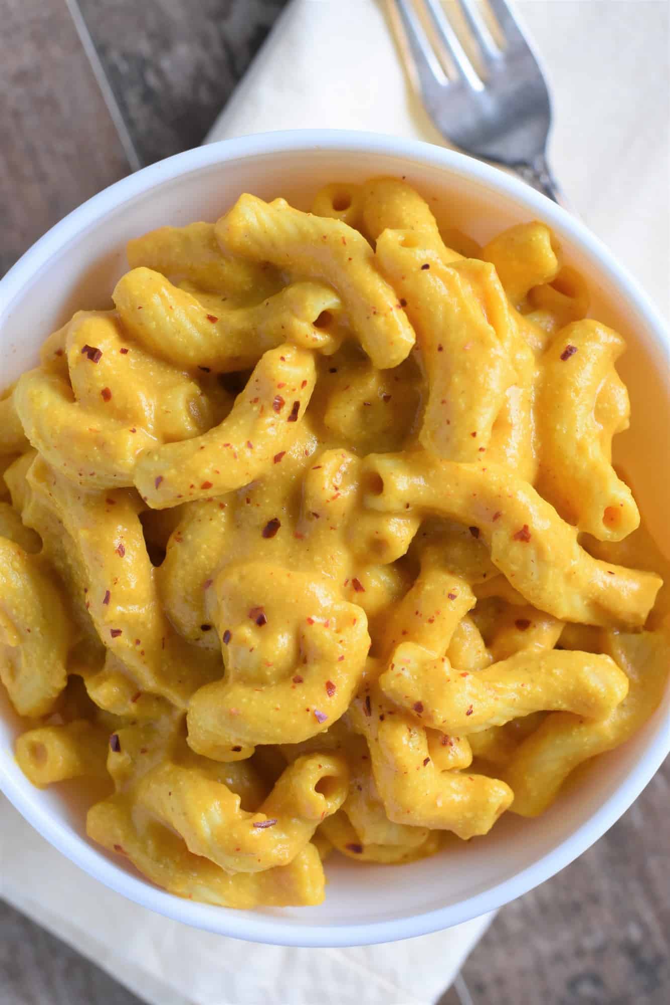 overhead of plant-based mac and cheese in a bowl topped with crushed red pepper flakes